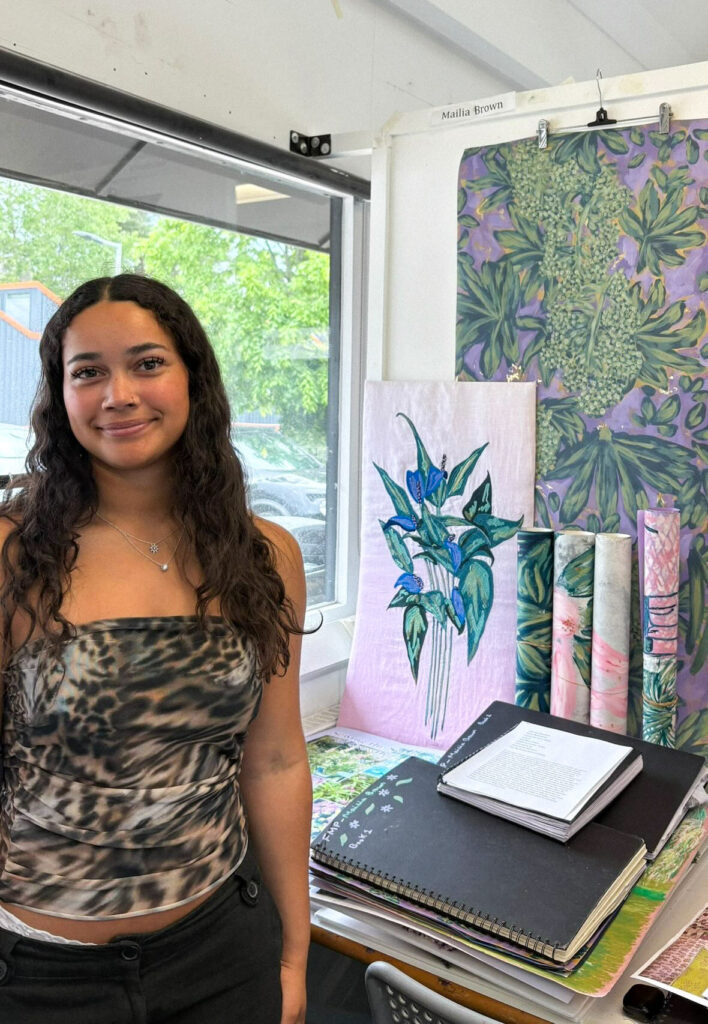 Mailia Brown in her studio with printed textiles and sketchbooks